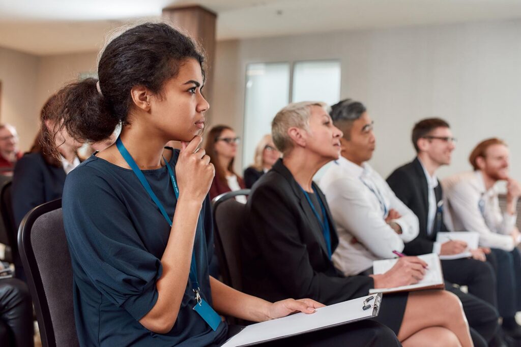 A photo of individuals listening to presentation